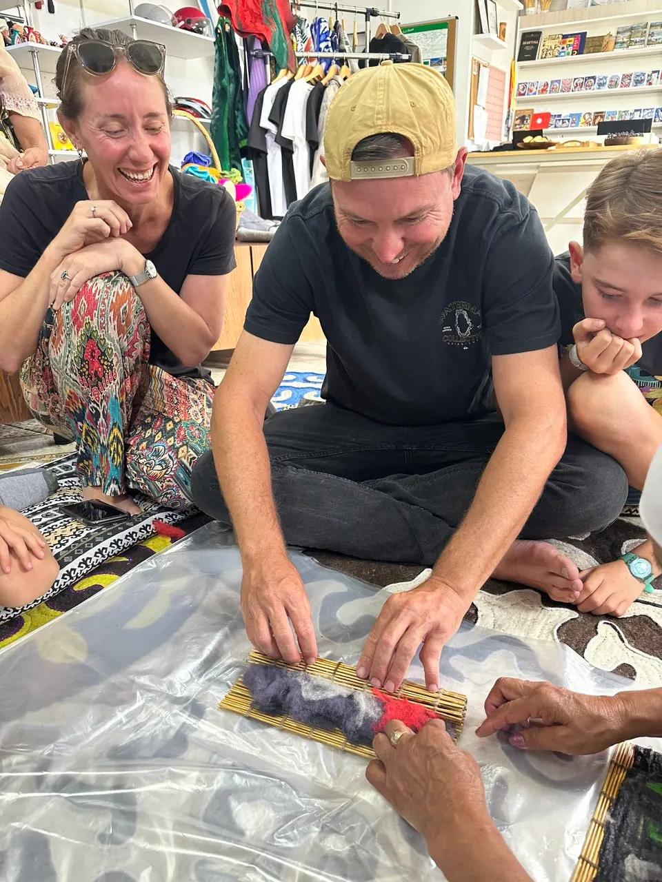 Guests rolling felt with a bamboo mat at a workshop